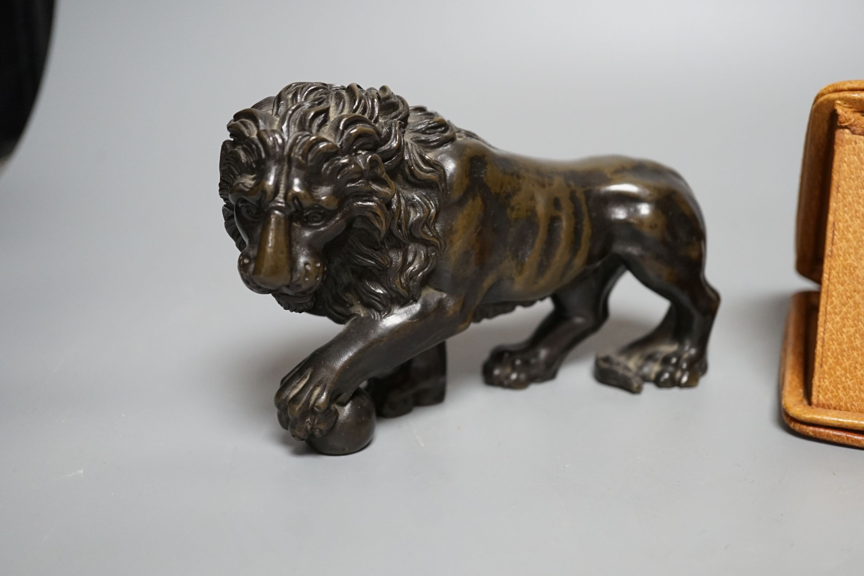 A bronze lion and Tiffany travelling watch, in tan leather case, lion 16.5 cms wide.